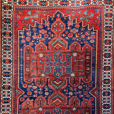 Alfombra Iraní Heriz con motivos geométricos en tonos rojos y azules 215cm x 315cm
