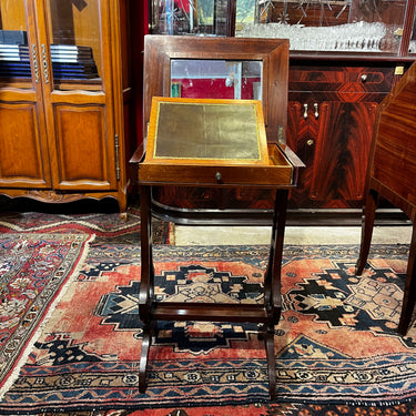 Mesa de salón en madera de caoba con escritorio atril y crucetas en lira, s. XIX